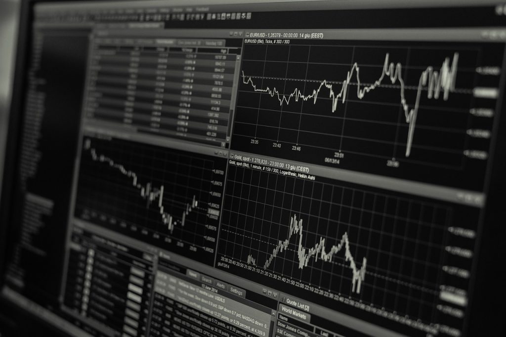 Trading app and stock-market board showing semiconductor share prices and ETF charts rising and falling