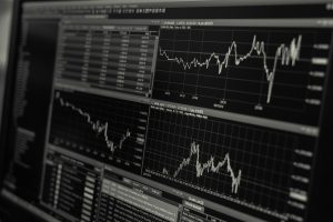 Trading app and stock-market board showing semiconductor share prices and ETF charts rising and falling