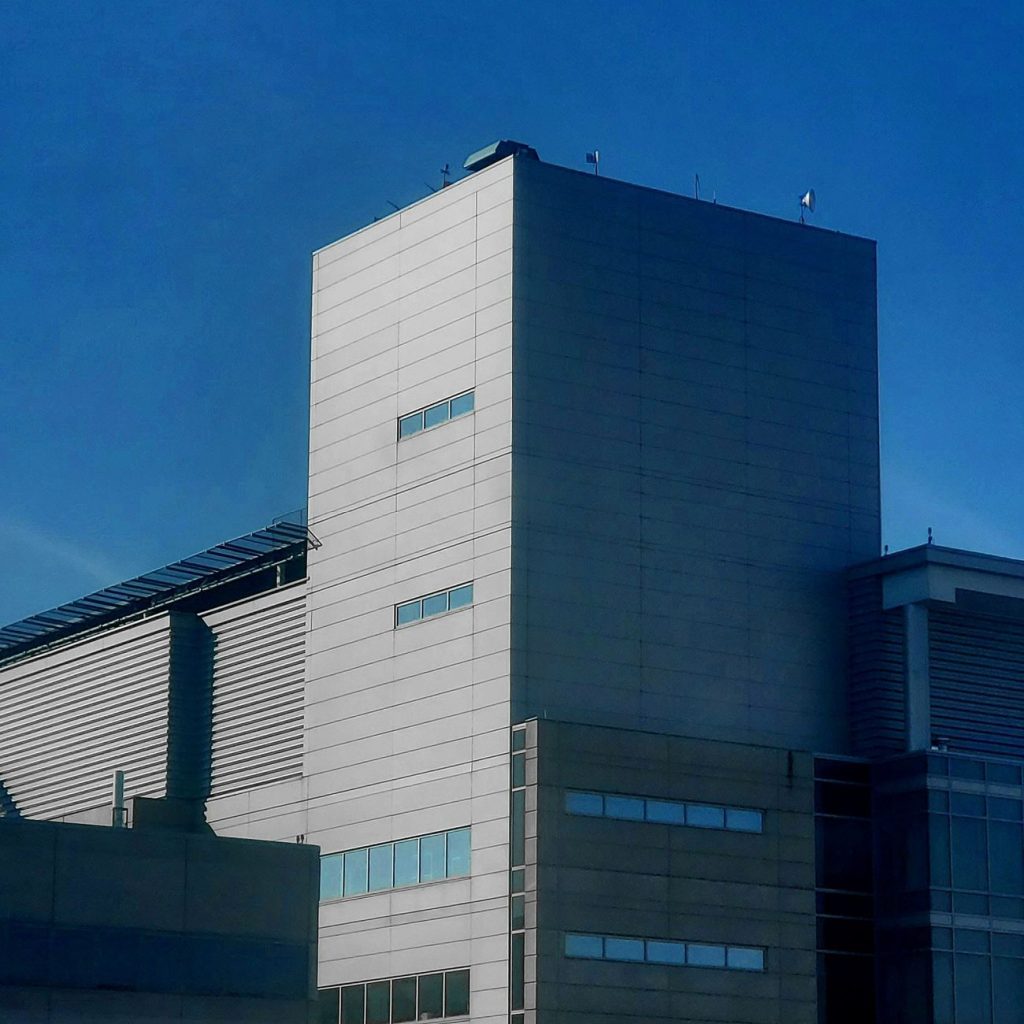 Aerial view of a large data center complex with cooling units and power lines beside rural farmland