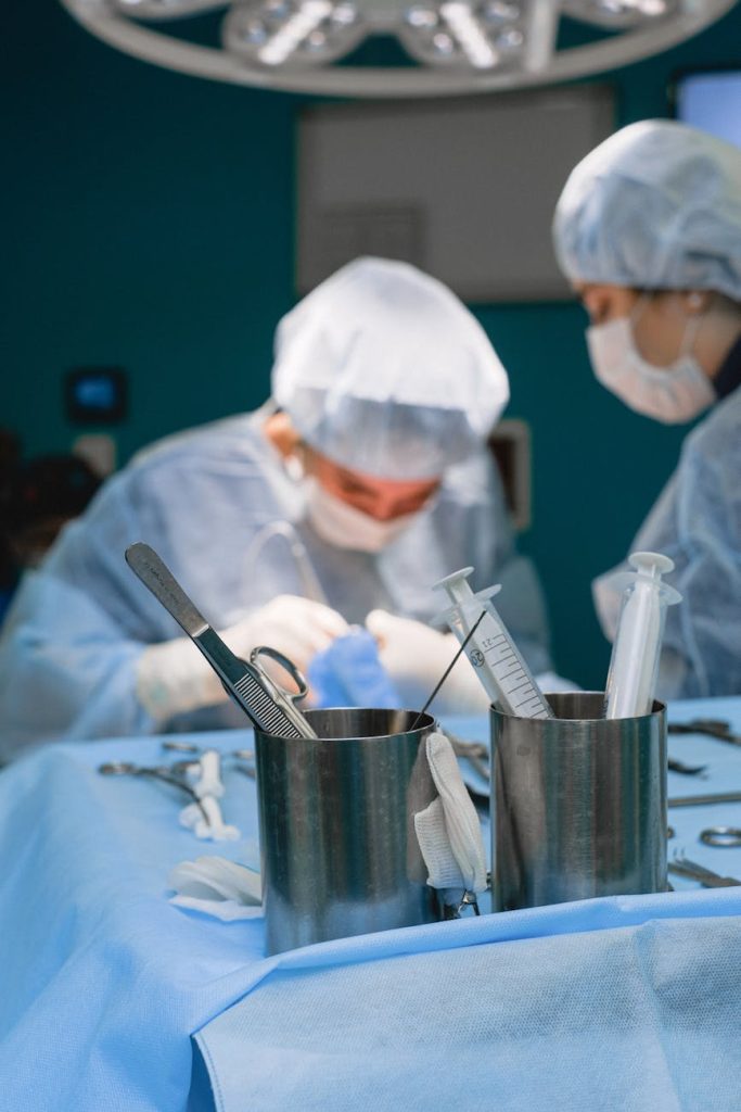 Surgical team in blue scrubs performing an organ transplant operation in a brightly lit operating room