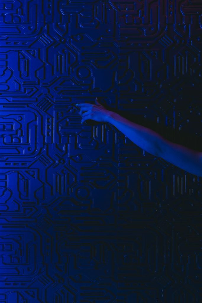 Conceptual image of a hand reaching for a brake pedal amid glowing AI circuit patterns