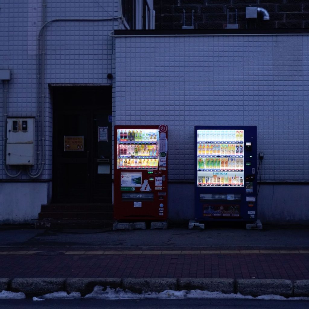 Exterior of a South Korean convenience store at dusk with a parcel pickup counter visible inside