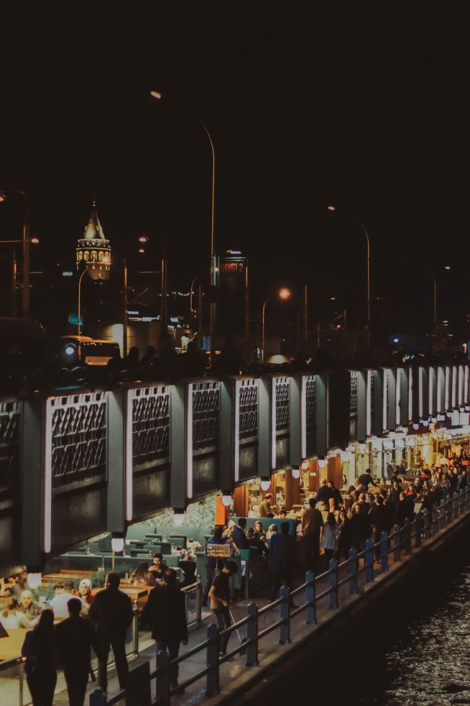 Glowing food stalls and crowds at a Korean coastal night market at dusk near the sea