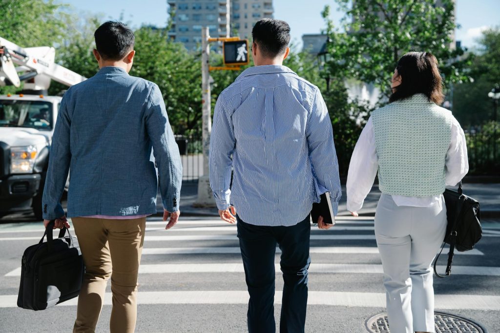 Workers walking through a modern Nordic city street with robotic and digital technology visible in the background
