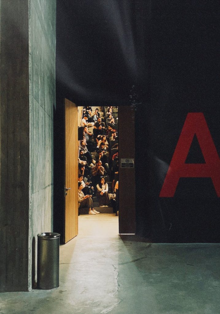 Film students in a lecture hall watching a presentation on AI visual-effects software displayed on a large screen