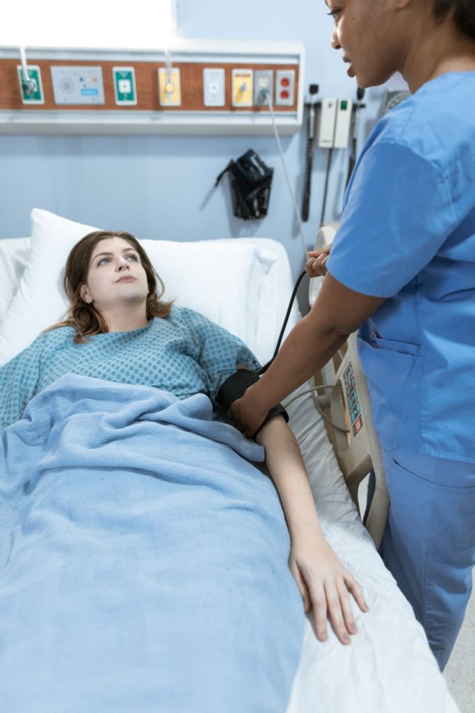 An elderly patient consults with a doctor and nurse in a bright modern hospital room