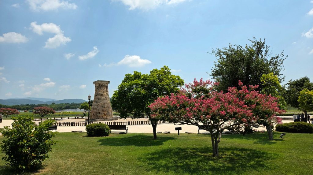 Ancient stone Cheomseongdae observatory tower surrounded by colorful blooming flowers under a clear sky