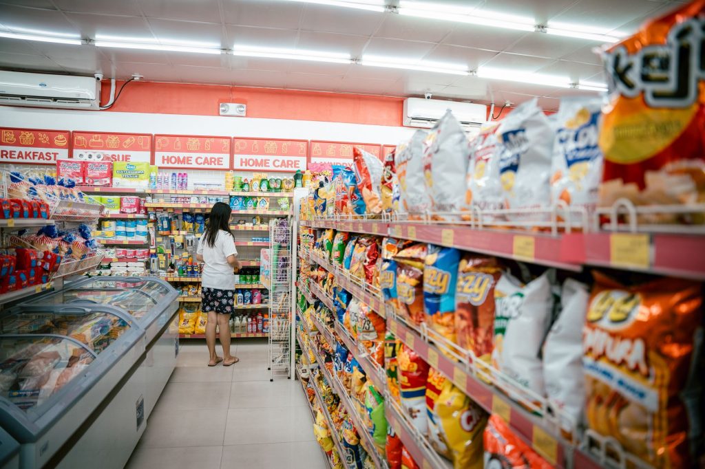 Supermarket shelves stocked with budget store-brand groceries and bright price tags
