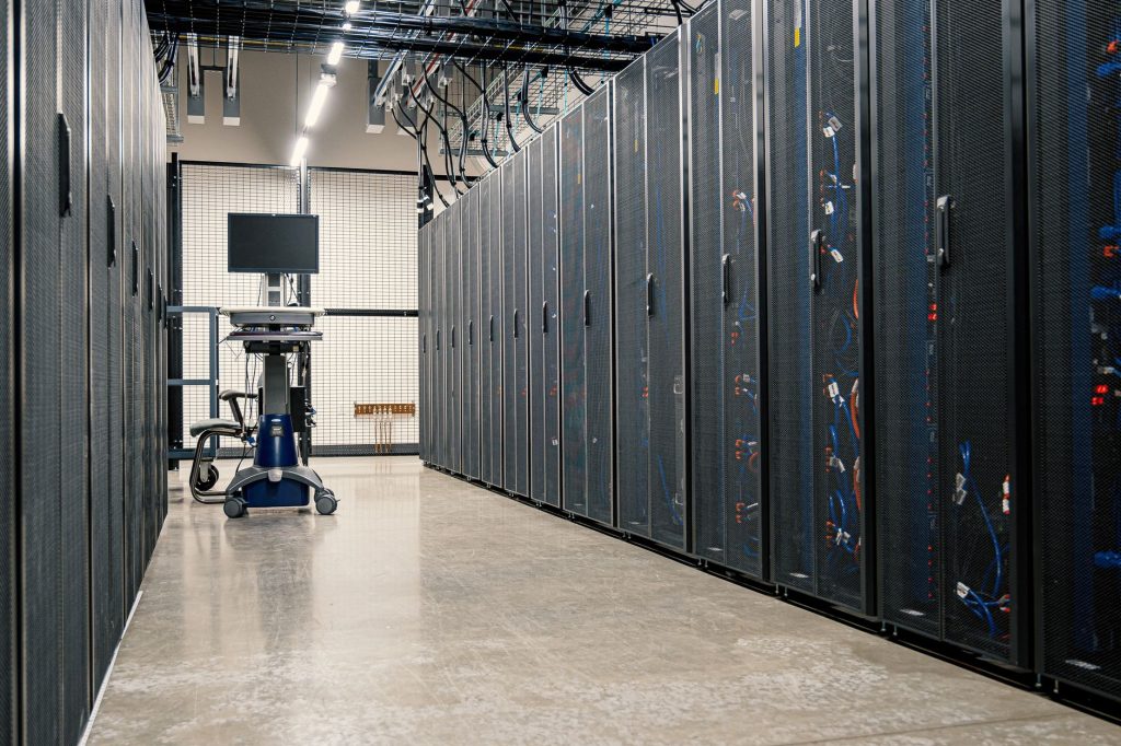 Rows of glowing server racks inside a large modern AI data center building
