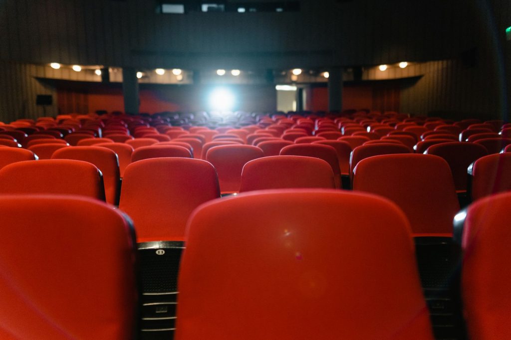 Crowds gathered outside a brightly lit film festival venue at dusk with a glowing marquee
