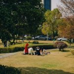 Residents and children gathering on the green central lawn of a modern apartment complex in South Korea