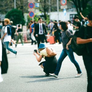 Young demonstrators holding rainbow and handmade signs at a daytime equality rally on a Seoul street